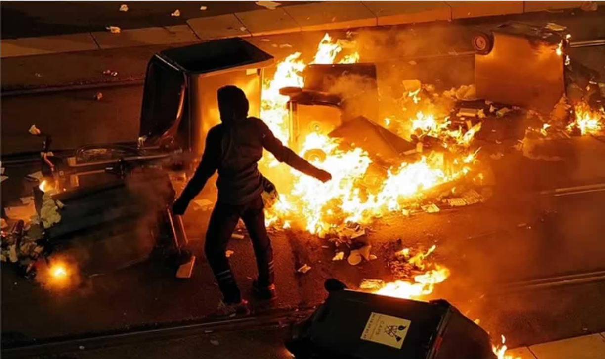 Un hombre incendia contenedores de basura en llamas, después de la victoria de Francia sobre Marruecos en la semifinal de la Copa del Mundo de Qatar 2022, en Niza el 14 de diciembre de 2022.