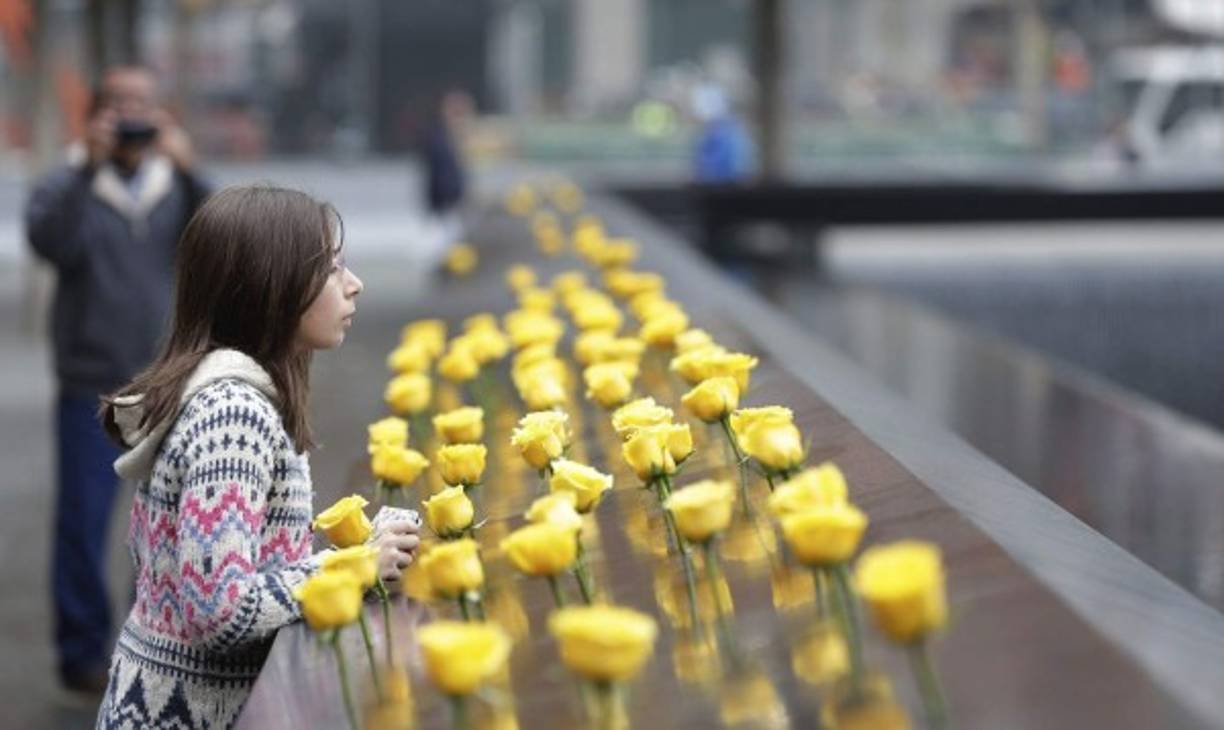 Una niña coloca flores en el memorial de los veteranos en Washington, donde están grabados más de 58,000 nombres de los soldados muertos en la guerra de Vietnam.