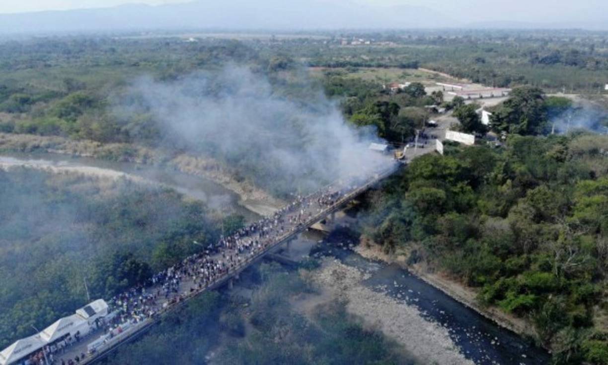 Luego de que los camiones atravesaran las barricadas en la frontera, los militares venezolanos lanzaron bombas lacrimógenas para dispersar a los voluntarios que acompañaban los vehículos y los incendiaron.