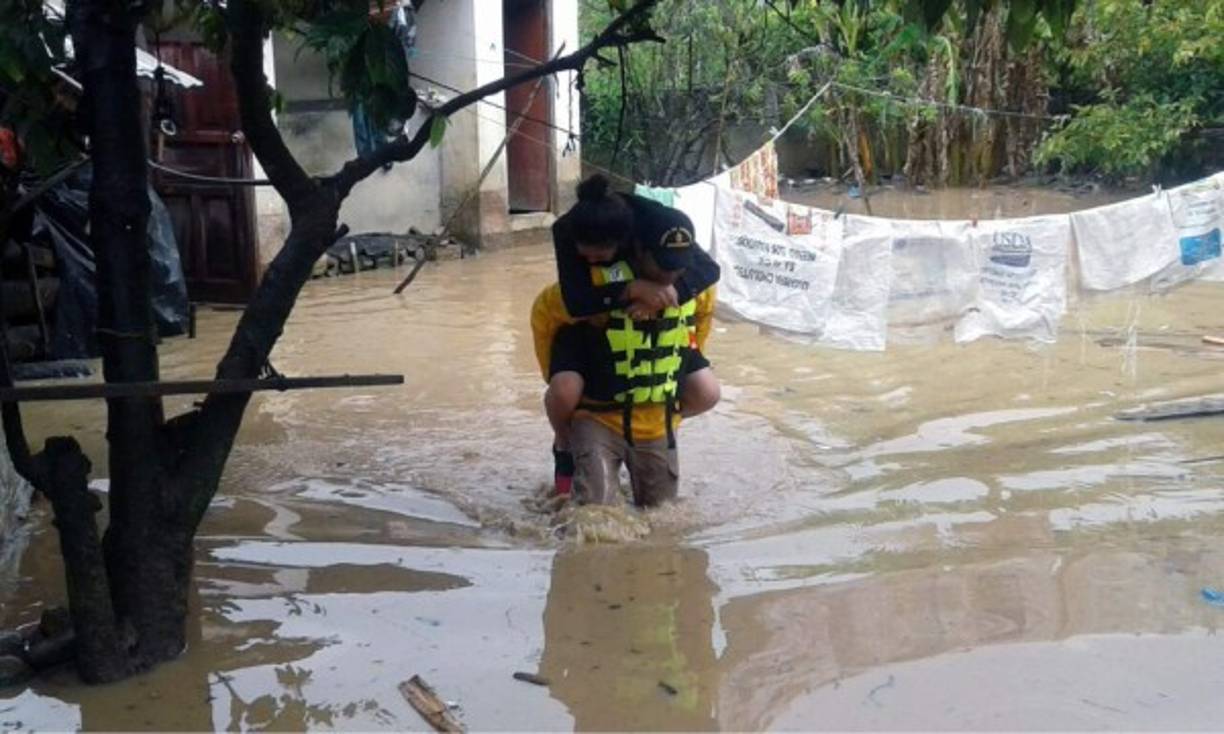 Esta foto muestra una evidencia clara de la enorme labor de los bomberos. En octubre del año pasado hna mujer embarazada dio a luz durante la evacuación de una zona vulnerable a las lluvias en Intibucá, en el occidente de Honduras. <br/>Los bomberos atendieron a María Celenia Gómez (30), originaria de San Francisco de Opalaca, quien dio a luz a una niña en su casa de habitación amenazada de ser inundada si continúan las lluvias. Uno de ellos no tuvo reparos y se la subió a la espalda en medio de la inundación.