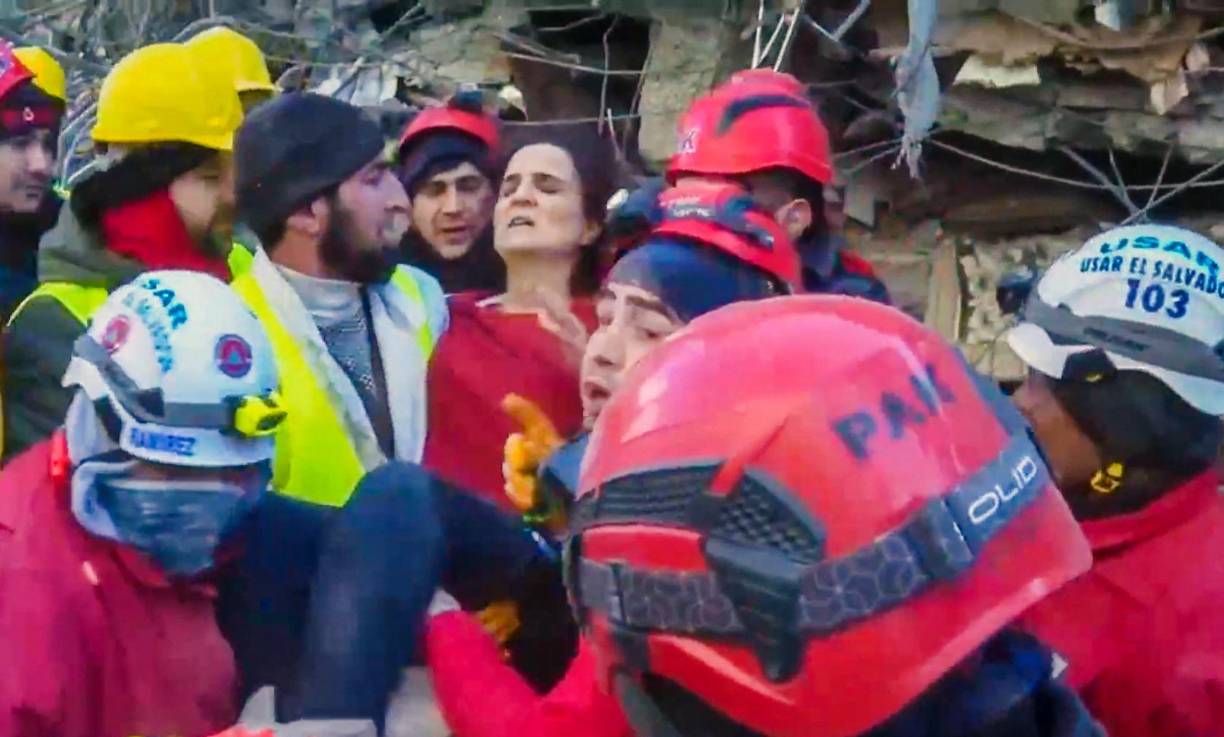 También se visualiza cómo sacan a una mujer, que logra mover los brazos y a la que le colocan un cuello ortopédico antes de acostarla en otra camilla.