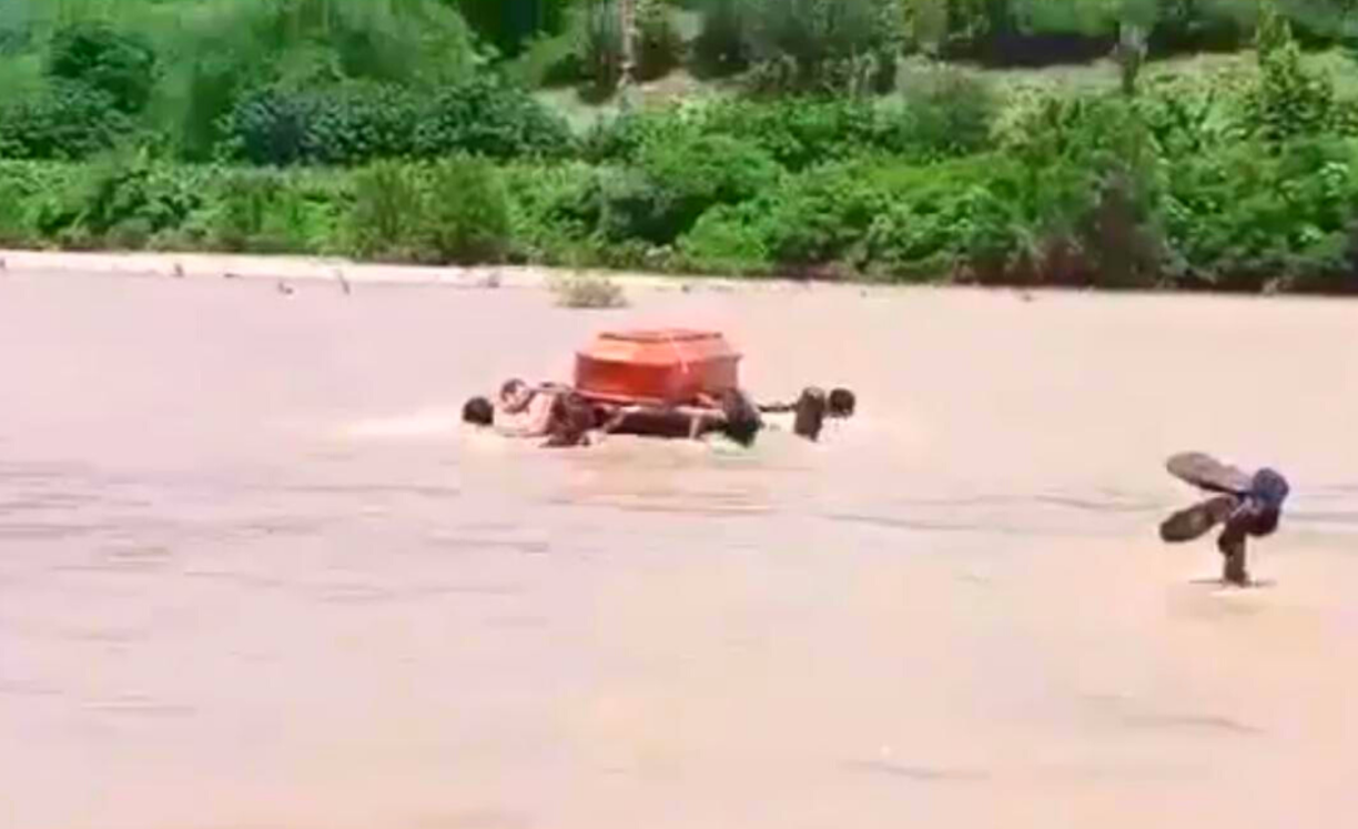 Ante la falta de un puente para poder cruzar, las personas se ven obligadas a cruzar a sus difuntos a través del río Choluteca.