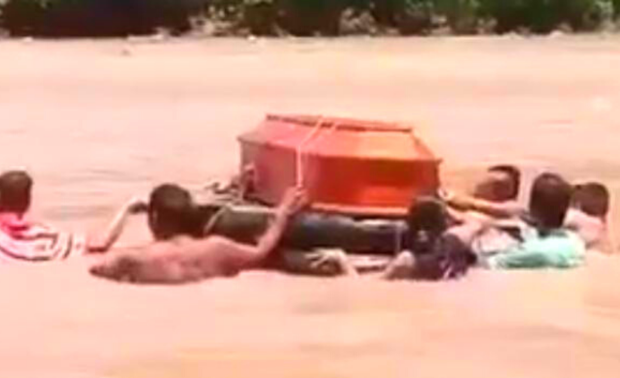 Entre varios ciudadanos cargaron el féretro en sus hombros y comenzaron a nadar.