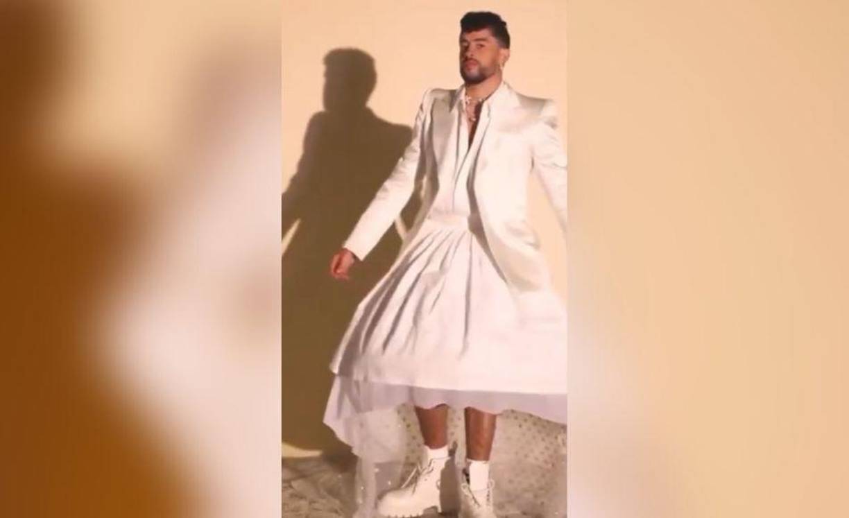 Bad Bunny no solo aparece vestido con distintos cambios de ropa, incluyendo una falda de alta costura, a juego con una chaqueta y botas blancas, de Louis Vuitton.
