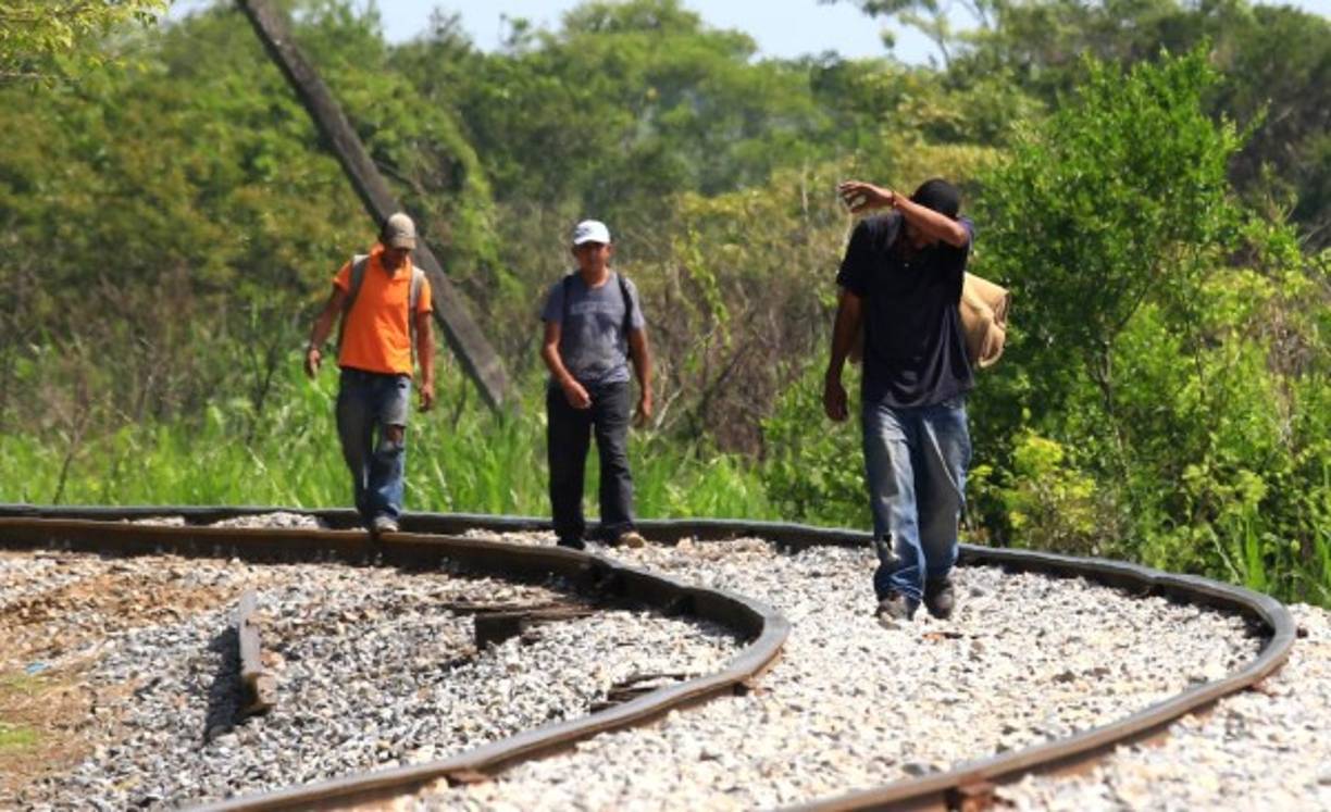Un grupo de migrantes camina por los rieles del tren sin papeles ni protección en su travesía por México.