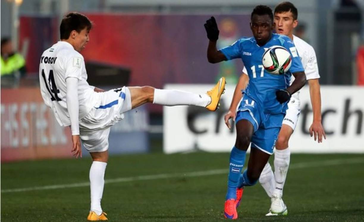 El uzbeko Khurshid Giyosov trata de quitarle el balón al hondureño Alberth Elis.