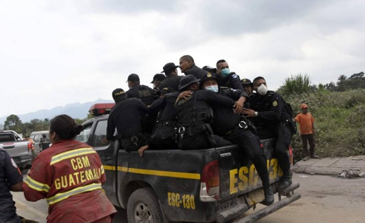 Policías se apiñaron en la paila de una patrulla para alejarse de la zona de peligro en las faldas del volcán.