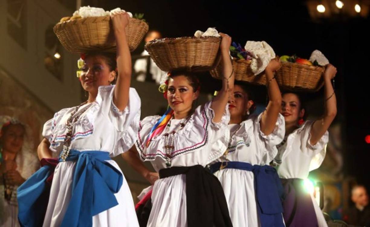 Jóvenes en trajes típicos participan en una representación artística.