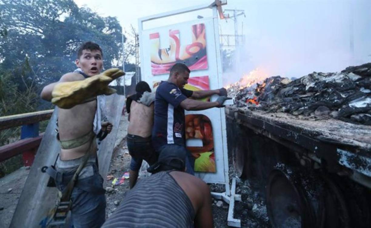 Al menos seis personas resultaron heridas cuando intentaban rescatar las cajas de medicamentos y alimentos de los camiones incendiados.
