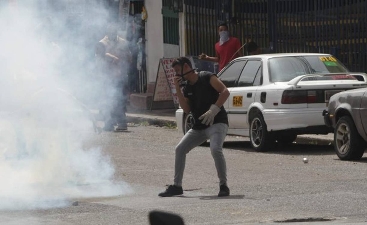 Los manfestantes utilizaron máscaras antigases para lanzar de regreso las bombas a los policías.