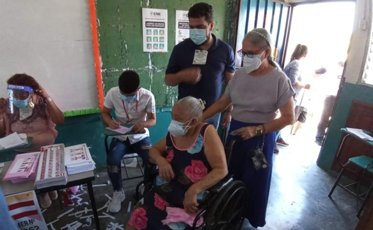 Doña Rosalina Lozano de 85 años llegó a votar en su silla de ruedas a la escuela Heriberto Castillo del barrio Cienaguita de Puerto Cortés. La acompañó su hija Esther.
