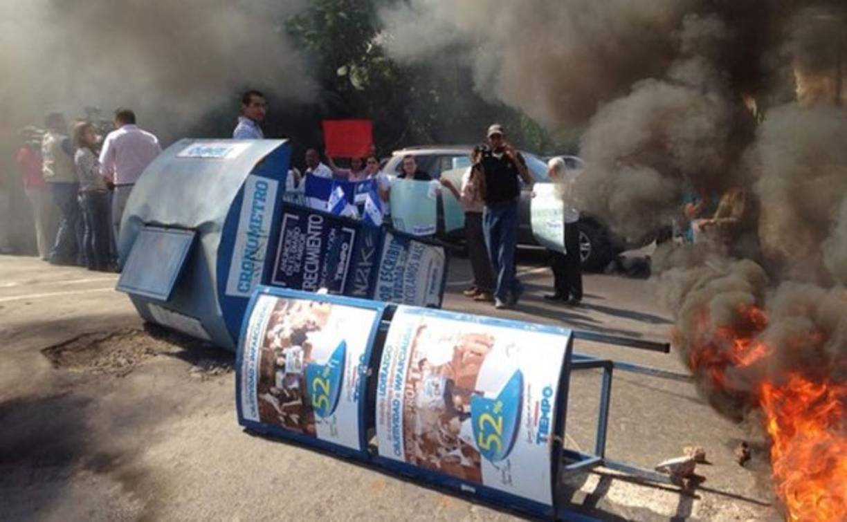 Los empleados botaron quioscos y quemaron llantas frente al edificio del periódico de los Rosenthal en la colonia Miramontes en Tegucigalpa. Esperan la intervención del Ministerio de Trabajo. Foto ‏@americahn