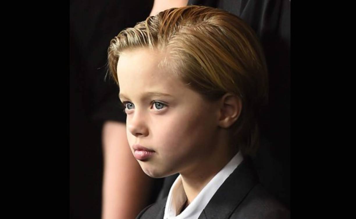 Vestida igual que sus hermanos, con traje oscuro, camisa blanca y corbata negra, y el pelo hacia atrás con gomina.