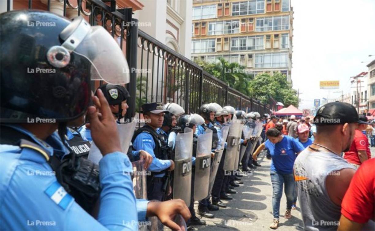 Elementos de la Policía tratando de evitar que la catedral fuera dañada durante la conmemoración sobre el Día Internacional del Trabajo.