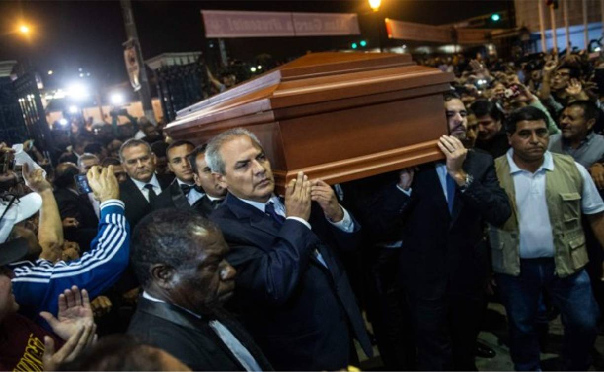 Alan Raul Simon Garcia (R) hijo del expresidente peruano Alan Garcia lleva el ataúd con los restos de su padre durante su velatorio en la sede de la Alianza de la Alianza Popular Revolucionaria Americana. Foto AFP.