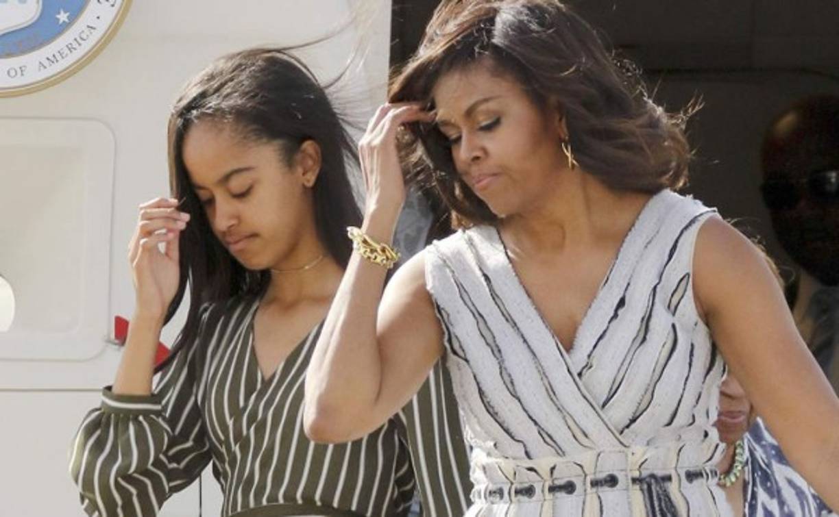 La primera dama de Estados Unidos viajó junto con sus hijas a España, fue a su llegada al aeropuerto que la hija mayor de Michelle tuvo que luchar con su vestido y el viento.