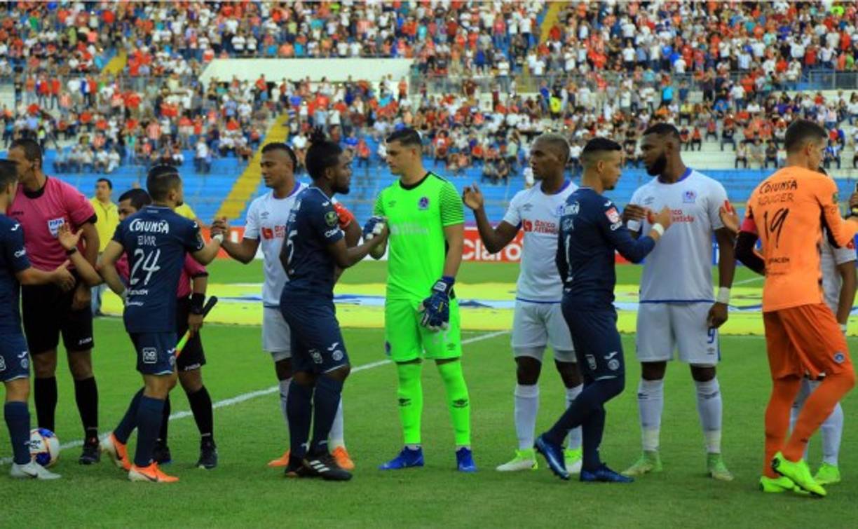 Los jugadores de Olimpia y Motagua se saludan antes del inicio del partido en el estadio Olímpico.