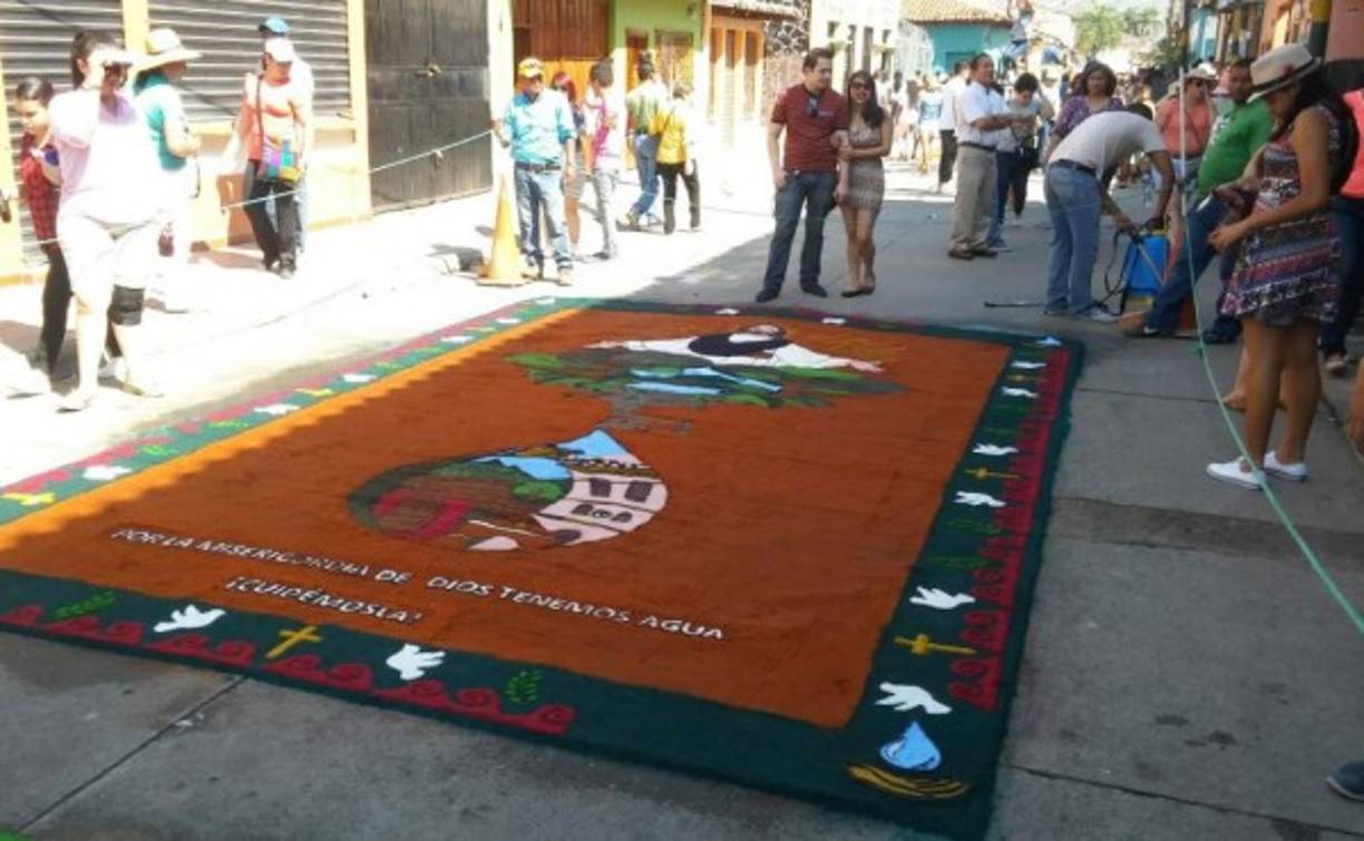 Personas aprecian una alfombra en la ciudad de Comayagua, zona central de Honduras, en el marco del Viernes Santo, el 25 de marzo de 2016.