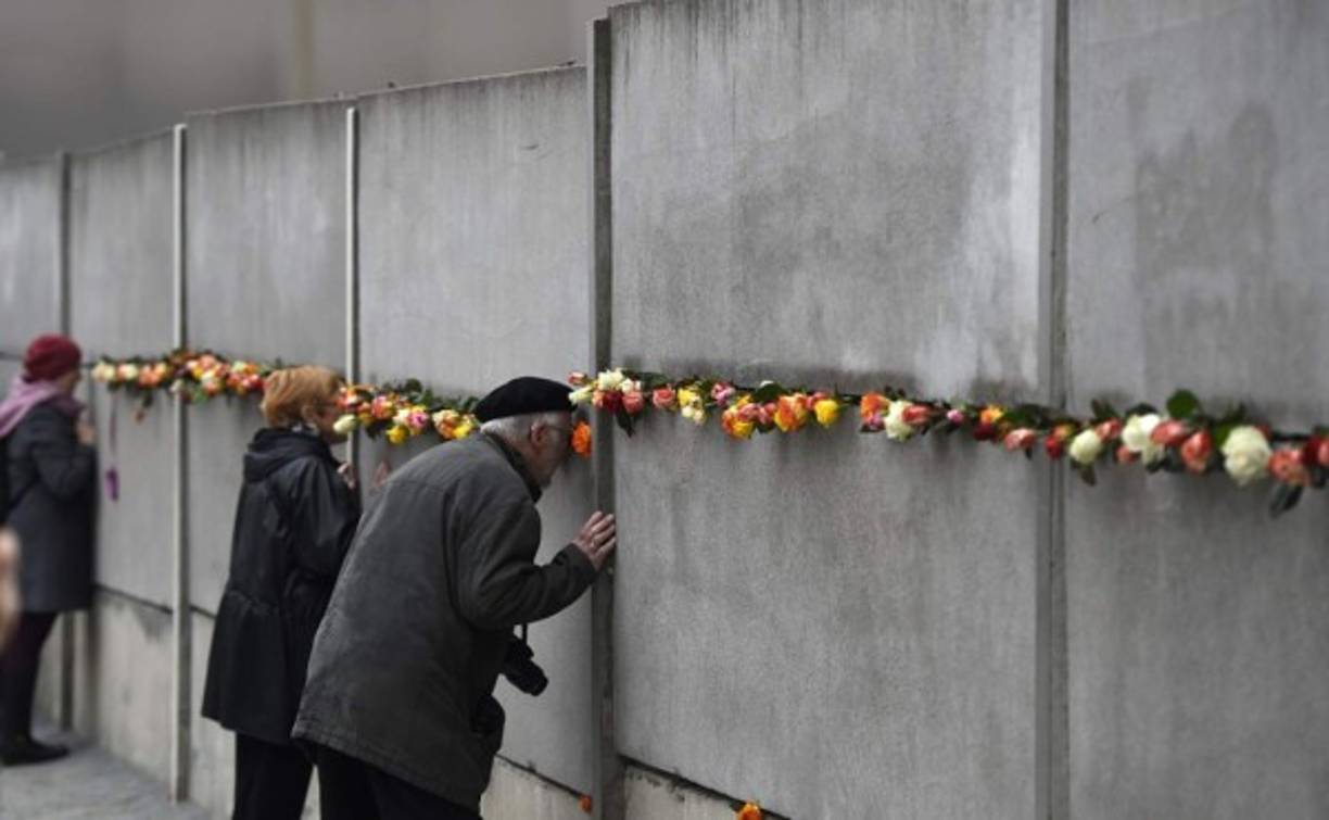 Los visitantes colocaron rosas y miraron entre la fisuras del muro.