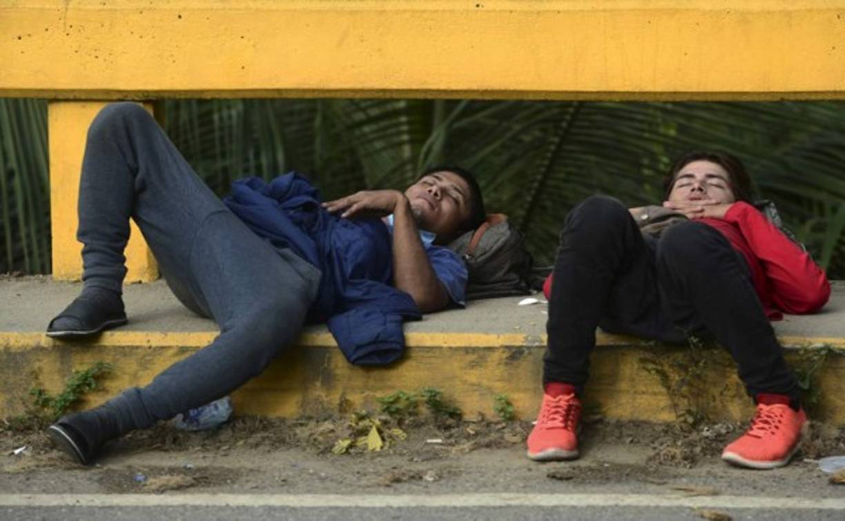 Los migrantes hondureños duermen en un puente en Corinto, Honduras, en la frontera con Guatemala. Foto AFP