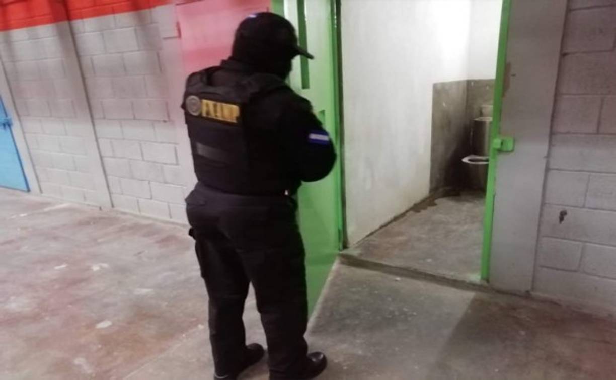 Uno de los agentes revisando los pasadores de las puertas de las celdas.