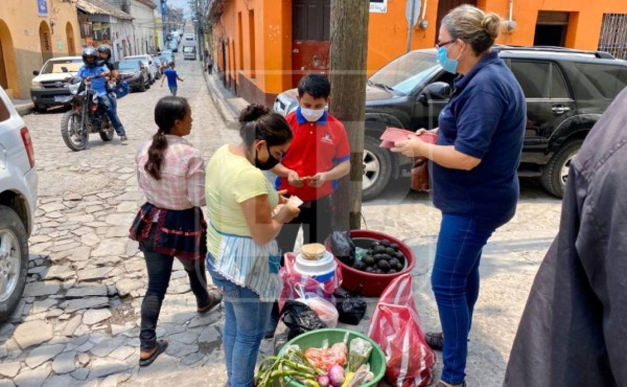 Vendedoras de verduras que se apuestan a diario frente de la farmacia Barnica, a una cuadra del Parque Central de Santa Rosa de Copán. Las comerciantes han continuado con sus negocios para poder generar ingresos económicos para sus hogares.