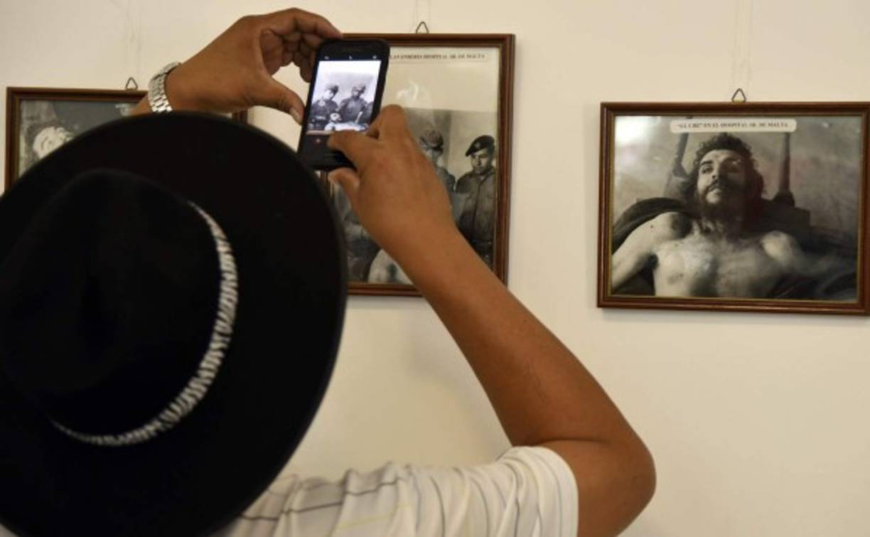 Un hombre toma una foto de la imágen que muestra el cuerpo del Che después de su fusilamiento. La imagen se encuentra en exhibición en la localidad de Valle Grande, Bolivia.