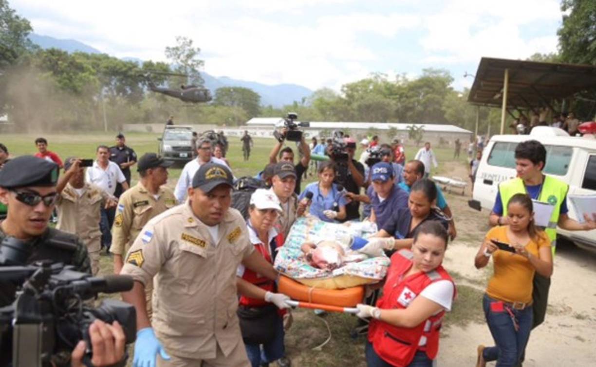 Voluntarios de los cuerpos de socorro mientras llevaban a una menor que fue víctima de fatal accidente.