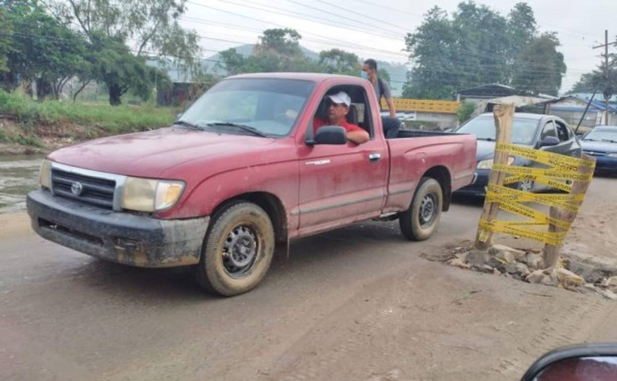 En la plancha de la carretera han puesto palos y señales para que los vehículos no se dañen. Tras las inundaciones, los pobladores piden la construcción de un tramo puente para que no queden incomunicados.