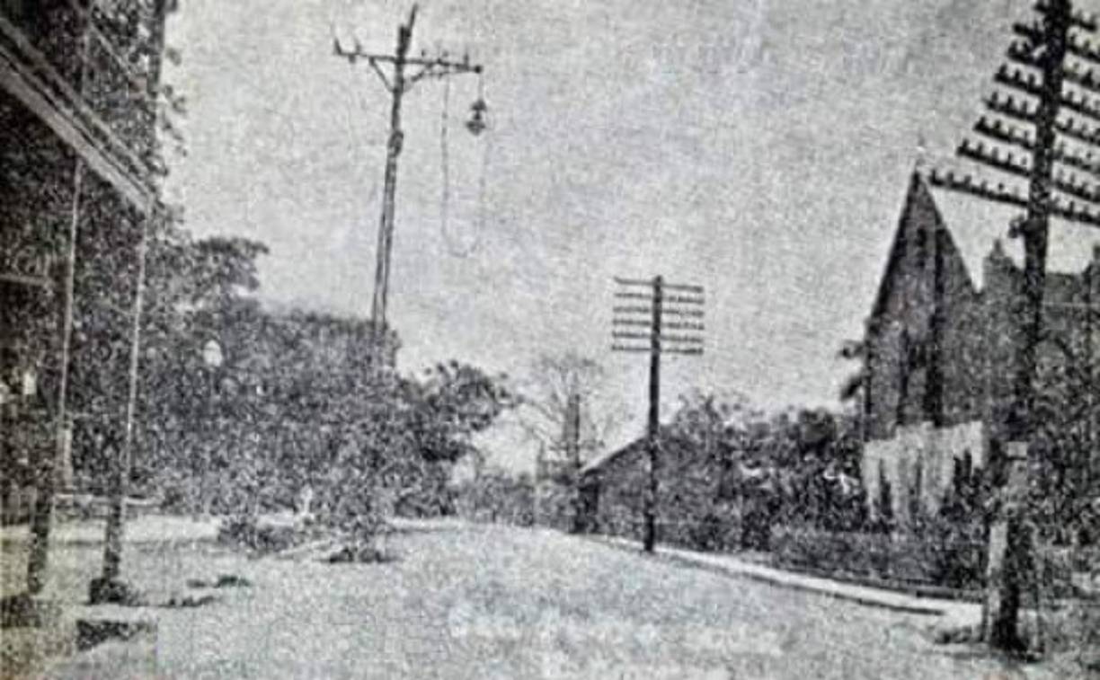 La Calle del Comercio frente a lo que hoy es la catedral. Se nota la antigua estructura del templo católico y los postes de alumbrado público de la época.
