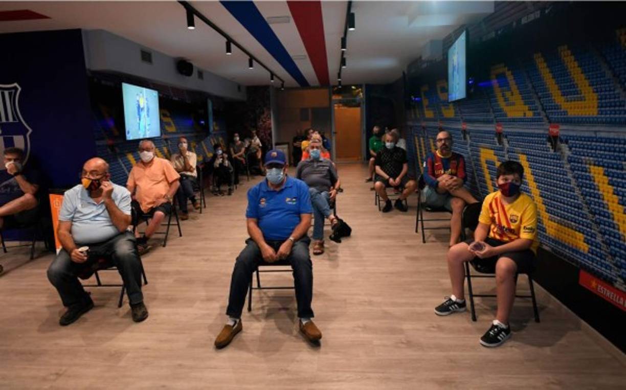 Aficionados del Barça con máscara facial miraron el partido contra el Mallorca en un club de fans en Barcelona.