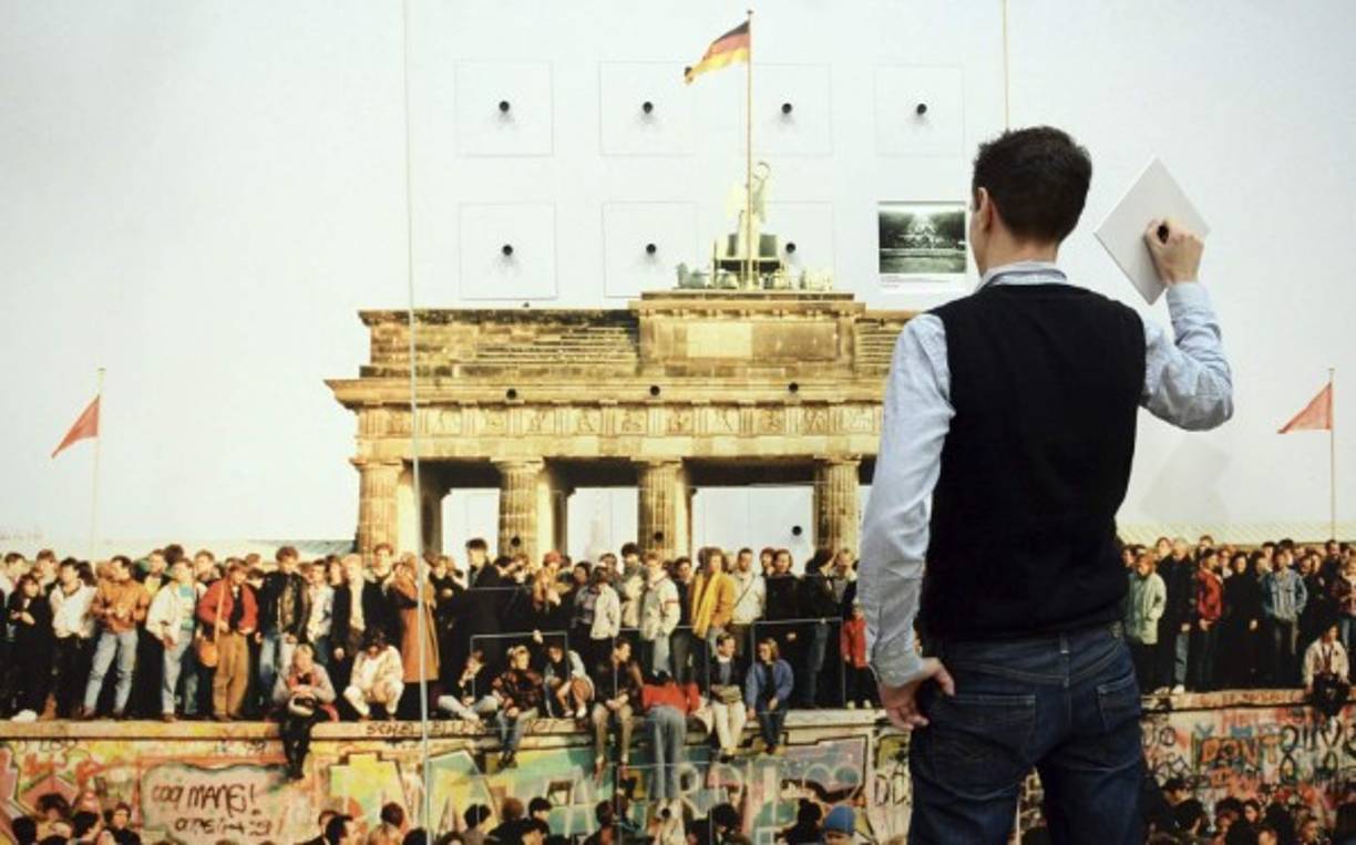 Un joven alemán observa una exposición interactiva sobre los momentos históricos del muro de Berlín.
