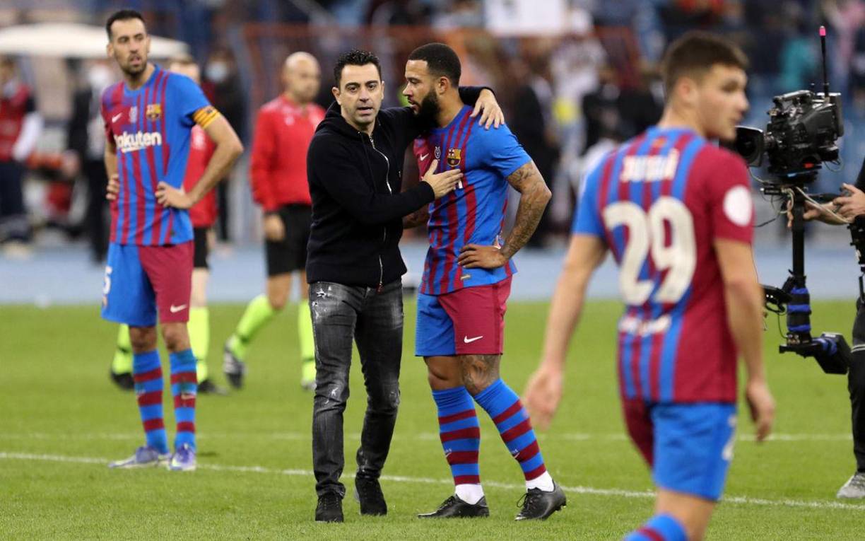Xavi Hernández entró al campo para consolar a sus jugadores. En la imagen abraza a Memphis Depay.