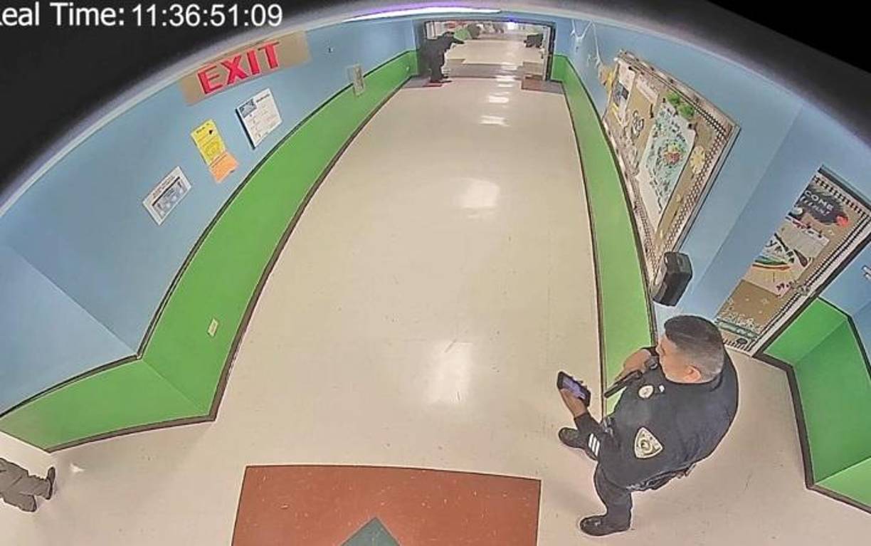 Varios policías armados con pistolas se ven llegando al pasillo de la escuela en cuestión de tres minutos después de los primeros disparos. Se dirigen al pasillo donde está sucediendo el tiroteo pero retroceden cuando el joven armado abre fuego desde el aula.