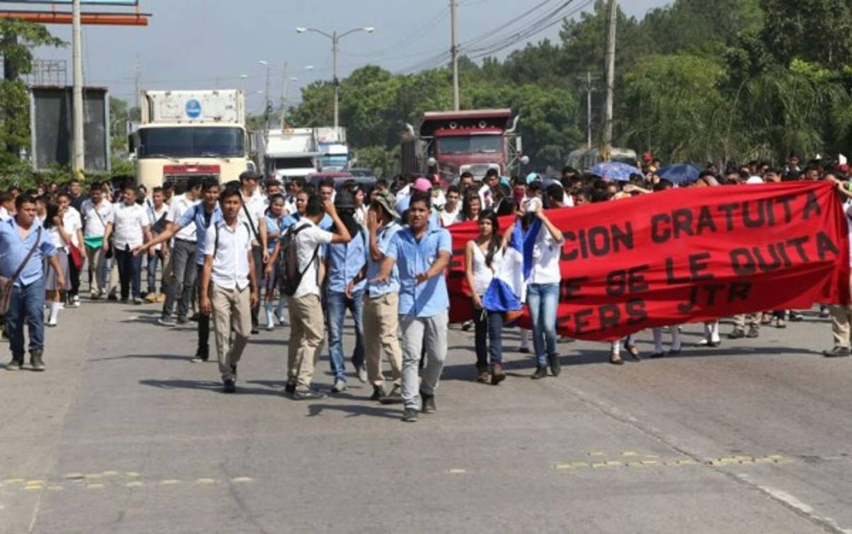 Students of the National Autonomous University of Honduras (UNAH) clash with riot police during a protest demanding justice for the murder of indigenous leader, coordinator of the Council of Popular and Indigenous Organizations of Honduras (COPINH), and environmental activist Berta Caceres in Tegucigalpa, on March 3, 2020. - Caceres was murdered at her house by unidentified armed gunmen on March 2, 2016. (Photo by ORLANDO SIERRA / AFP)