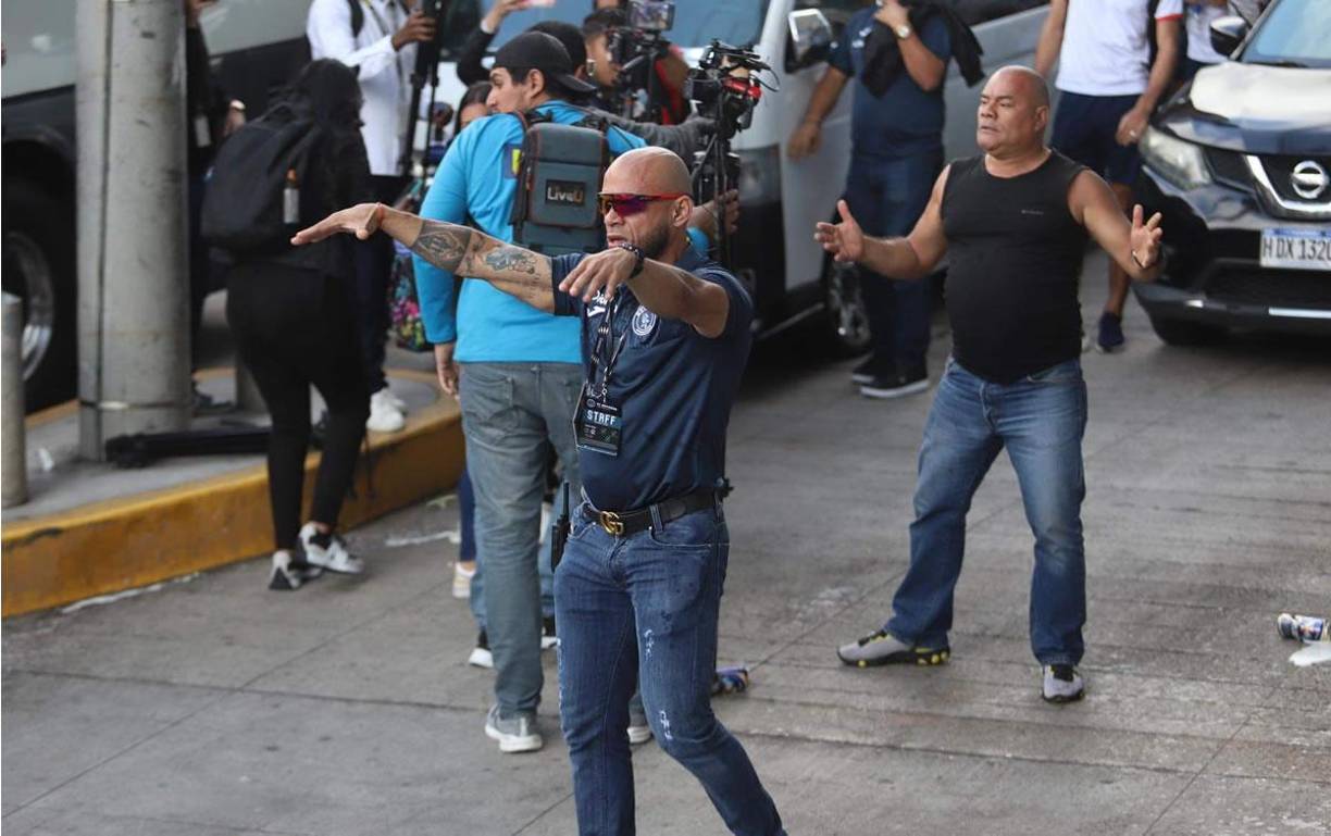 El miembro de seguridad privada del Motagua pidiendo calma a los aficionados motagüenses que lanzaban latas de cervezas a los jugadores del Olimpia.