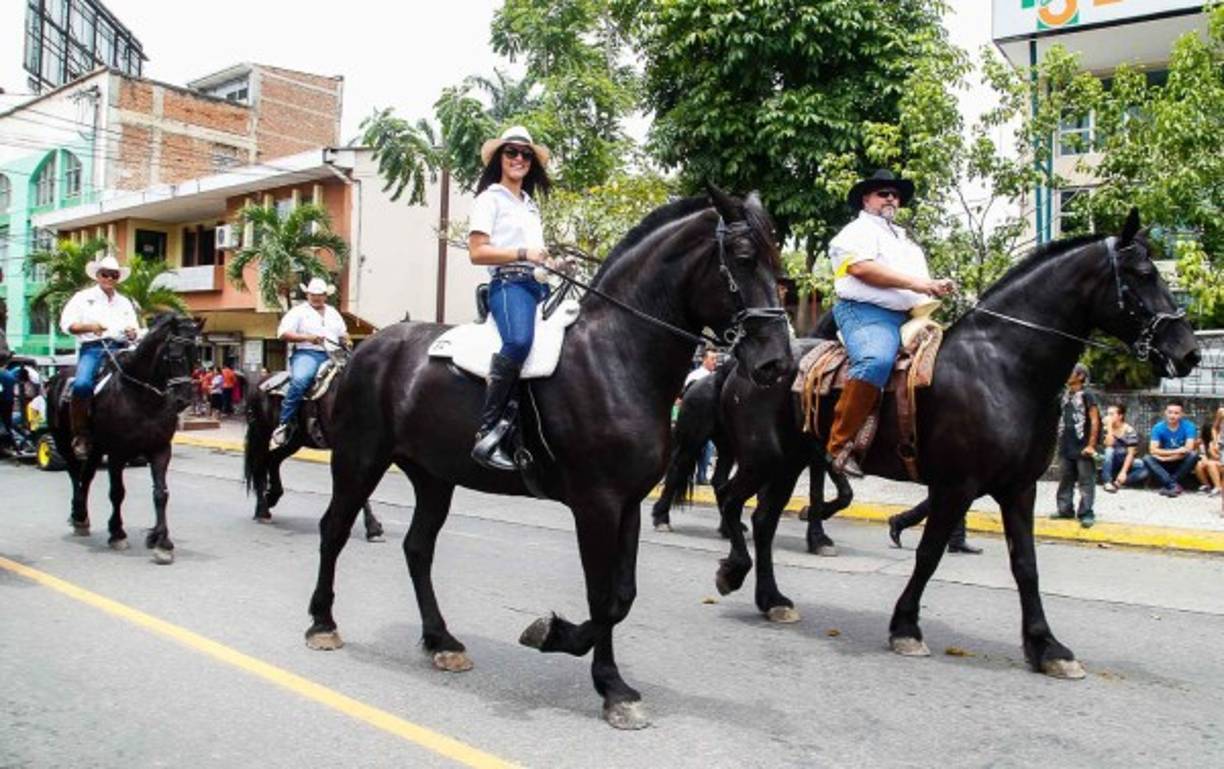 Una jinete, con su sombrero y botas, monta su caballo con mucho orgullo.