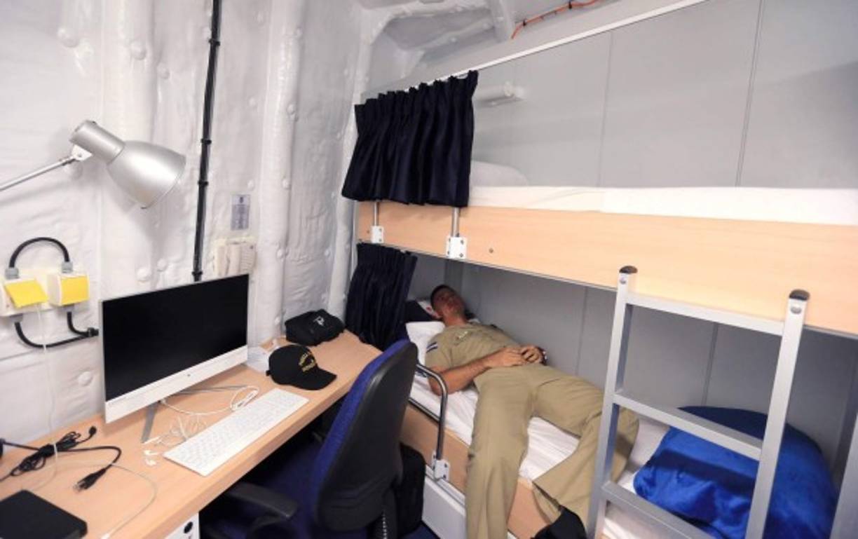 Tiene seis camarotes con dos camas cada uno, closets, baño, escritorio de trabajo y televisión.