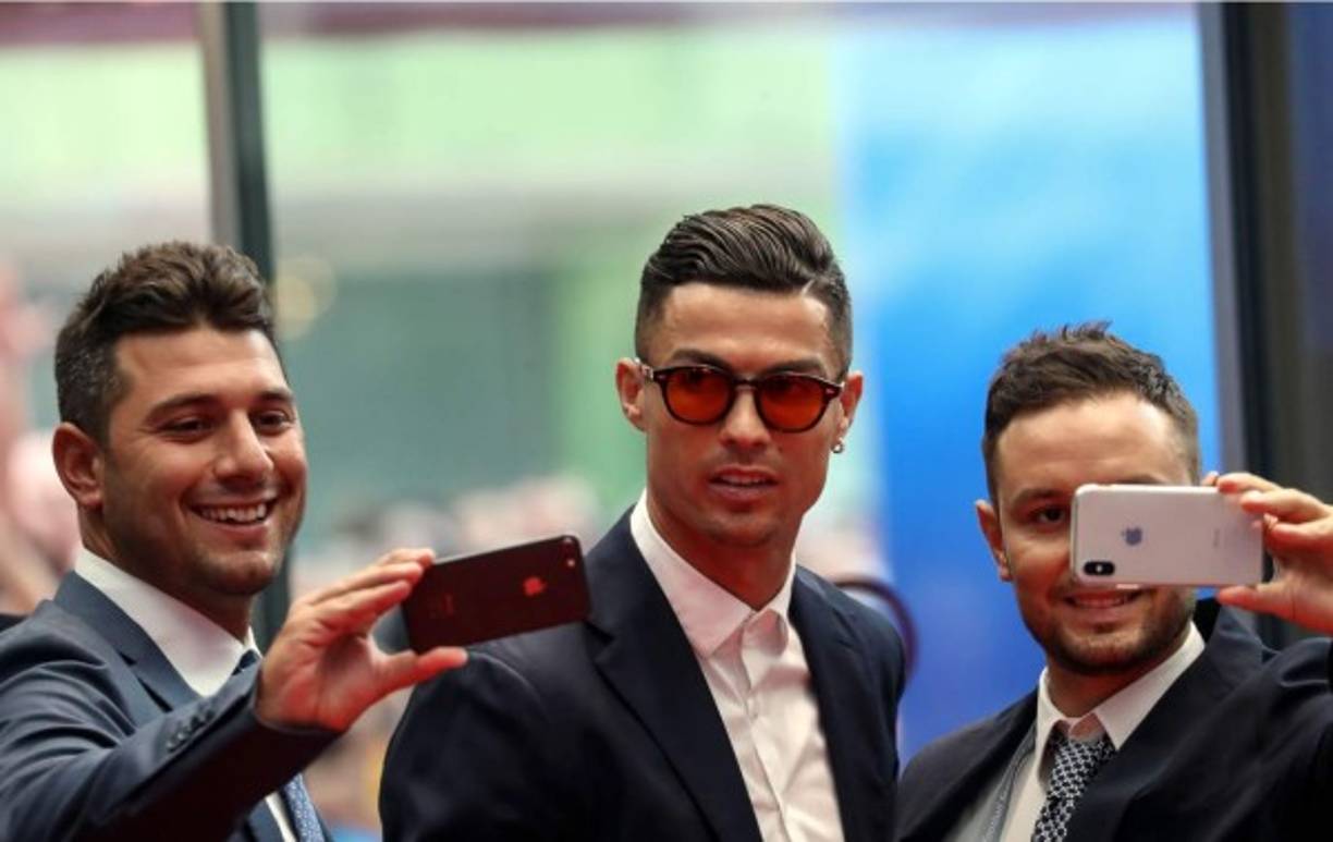 Cristiano Ronaldo posa para una selfie con estos aficionados en la alfombra roja.