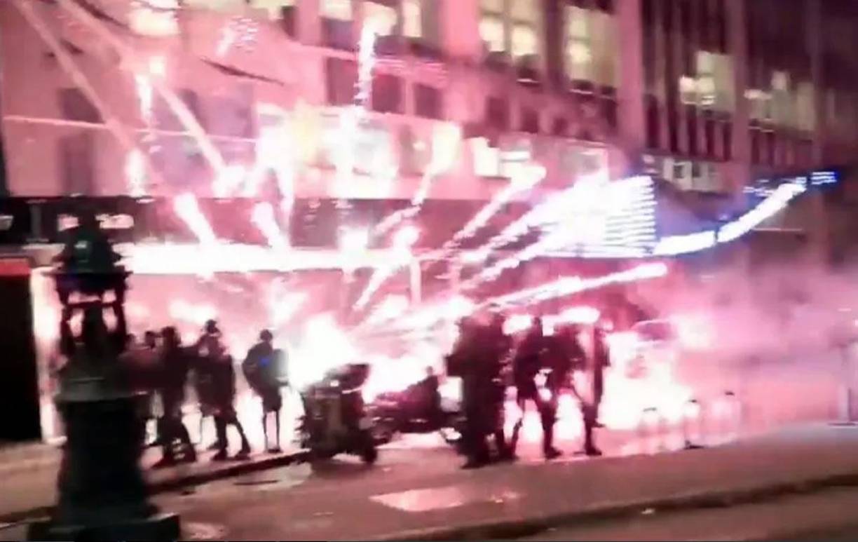 Los policías antidisturbios fueron alcanzados por los fuegos artificiales en París mientras miles de fanáticos salían a las calles.