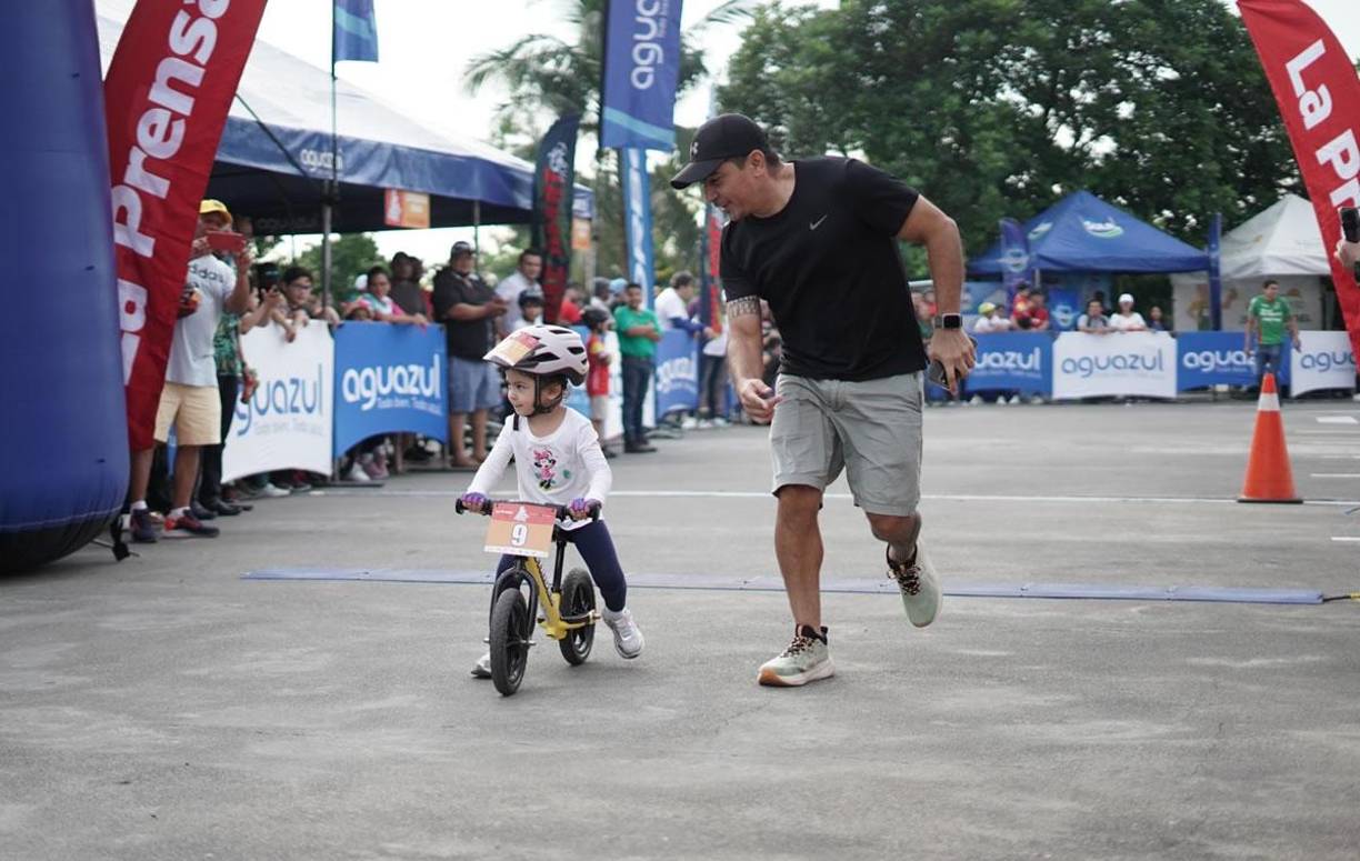 Un padre feliz de acompañar a su pequeña hija, quien fue la primera ganadora en la Vuelta Ciclística Infantil LA PRENSA 2024.