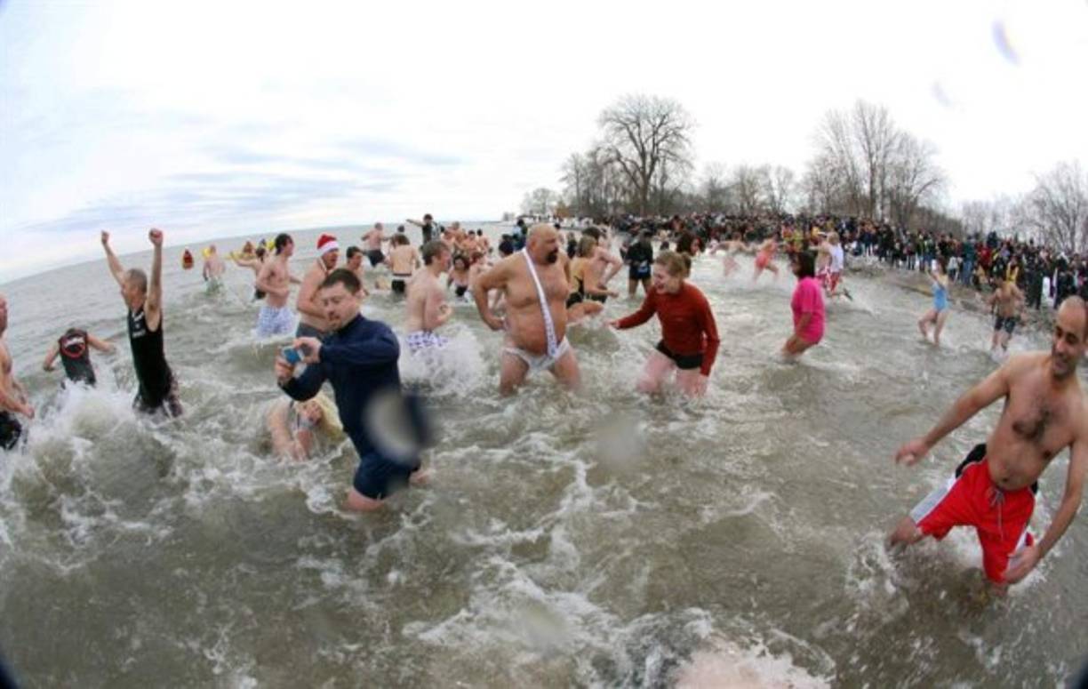Un grupo de personas participa en el tradicional chapuzón en las heladas aguas del lago Ontario (Canadá) con una temperatura de -14 grados hoy, viernes 1 de enero de 2015.