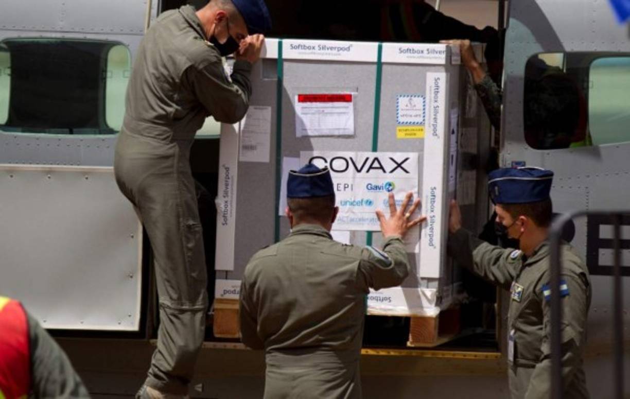 Militares hondureños ayudan a descargar las vacunas donadas bajo el mecanismo Covax, en la Base Aérea Hernán Acosta Mejía hoy en Tegucigalpa (Honduras). EFE