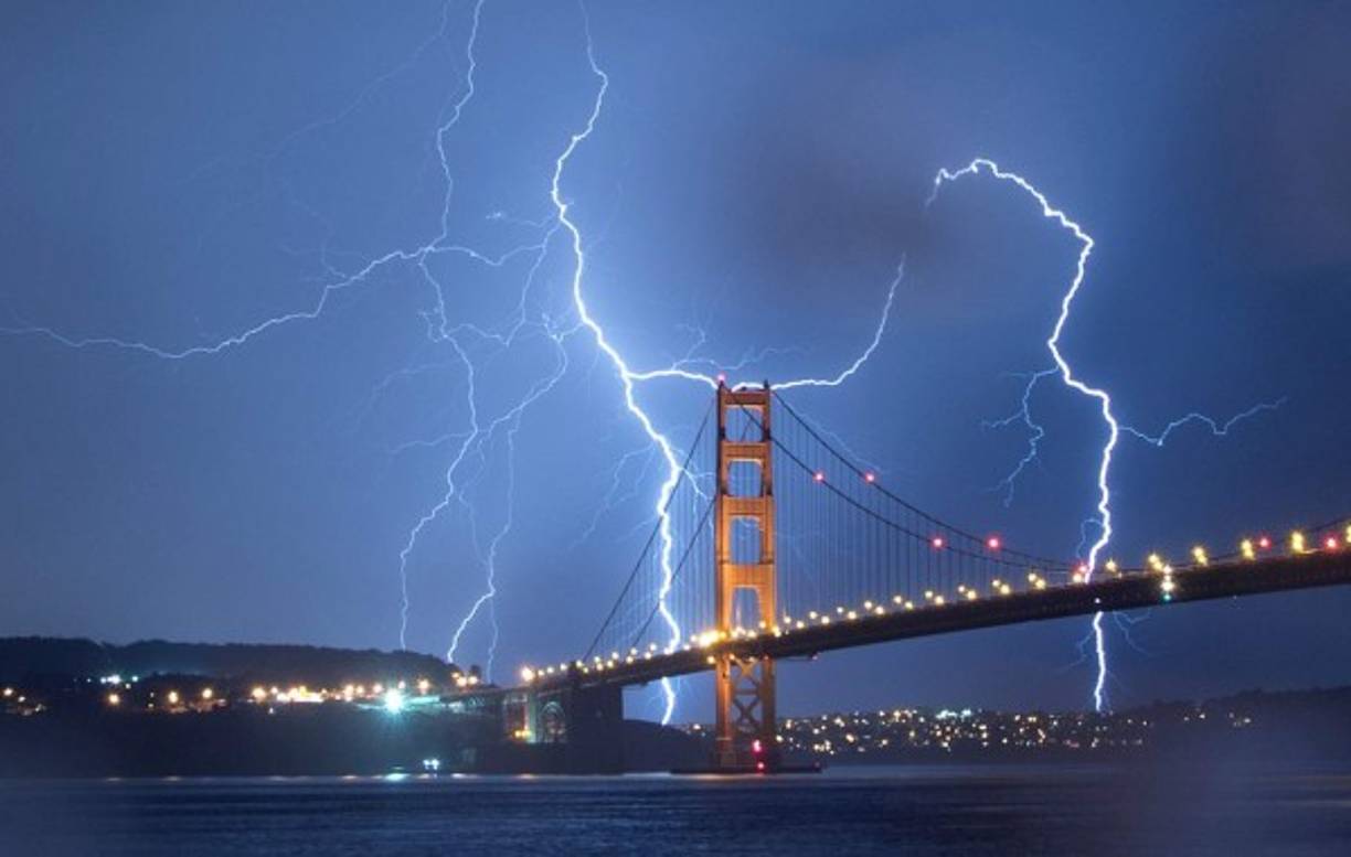 Iluminado por los rayos- Momento en que los rayos iluminan el puente Golden Gate en San Francisco.<br/><br/>