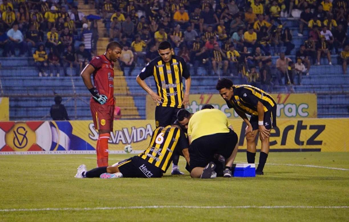 El cuerpo médico del Real España atendiendo a Devron García, quien sufrió un golpe en la cabeza tras un choque.