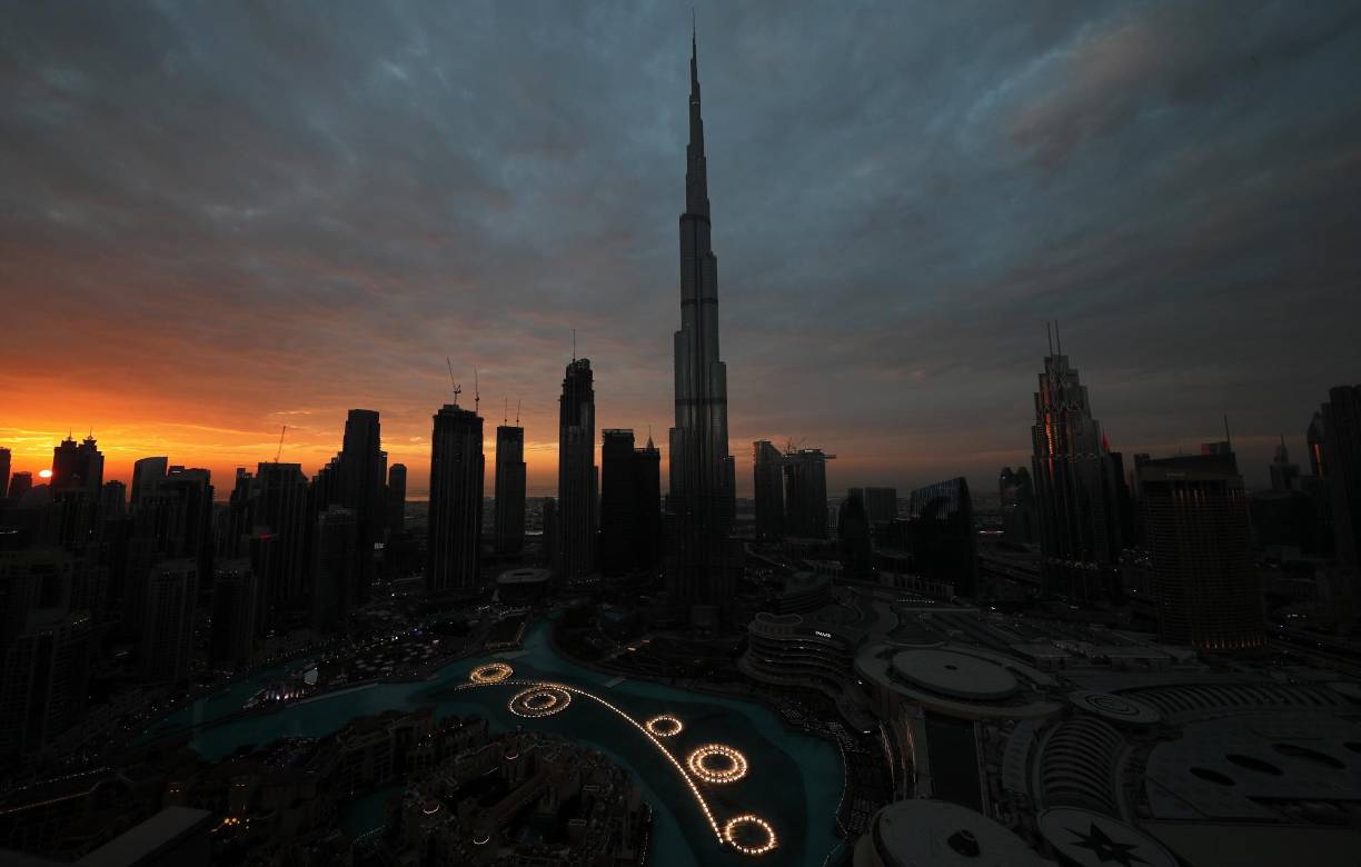 El sol se pone detrás de Burj Khalifa, el edificio más alto del mundo, antes de un espectáculo de fuegos artificiales en la víspera de Año Nuevo en los emiratos del Golfo de Dubai, Emiratos Árabes Unidos.