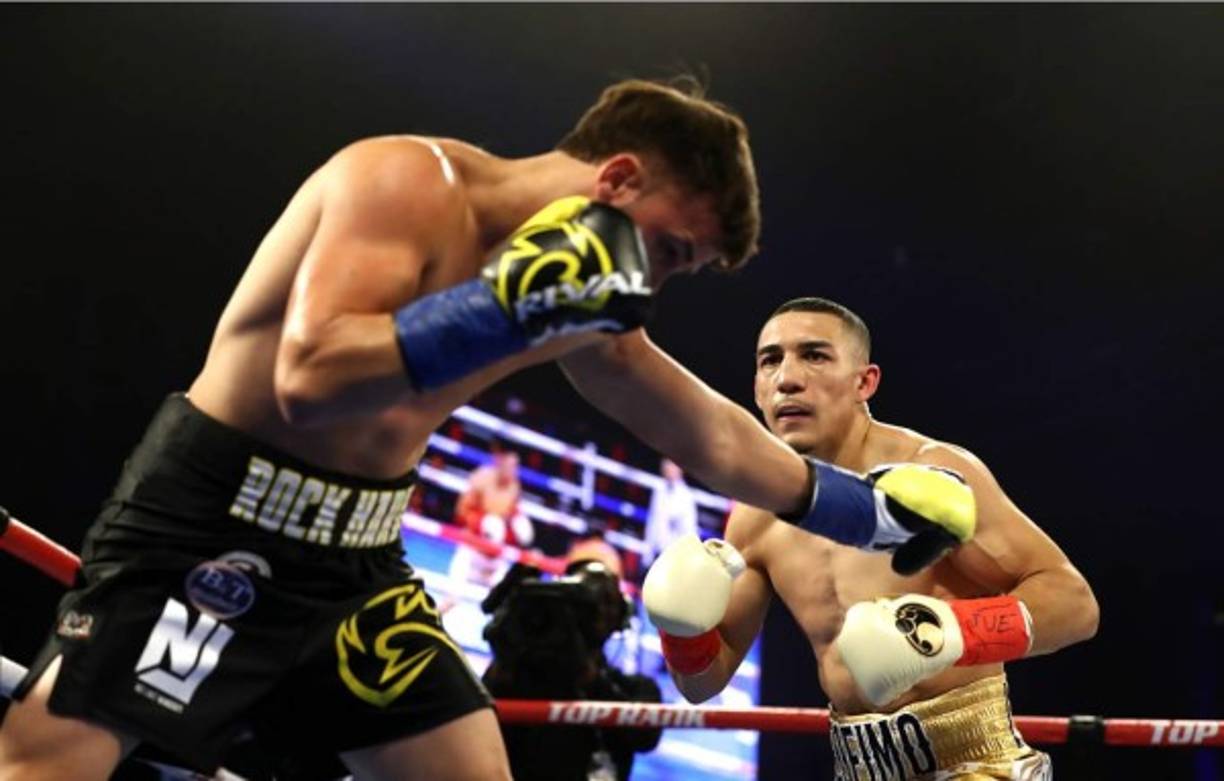 Teófimo López observa como Mason Menard va cayendo a la lona.