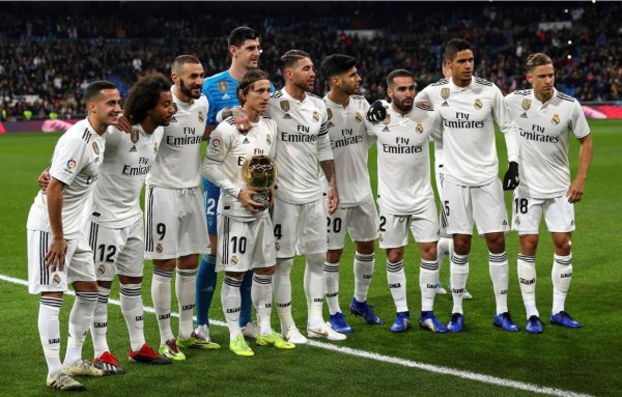 Luka Modric posó además sobre el césped con el trofeo y el resto de compañeros que salieron de inicio en el partido, correspondiente a la decimosexta jornada de la Liga Española.
