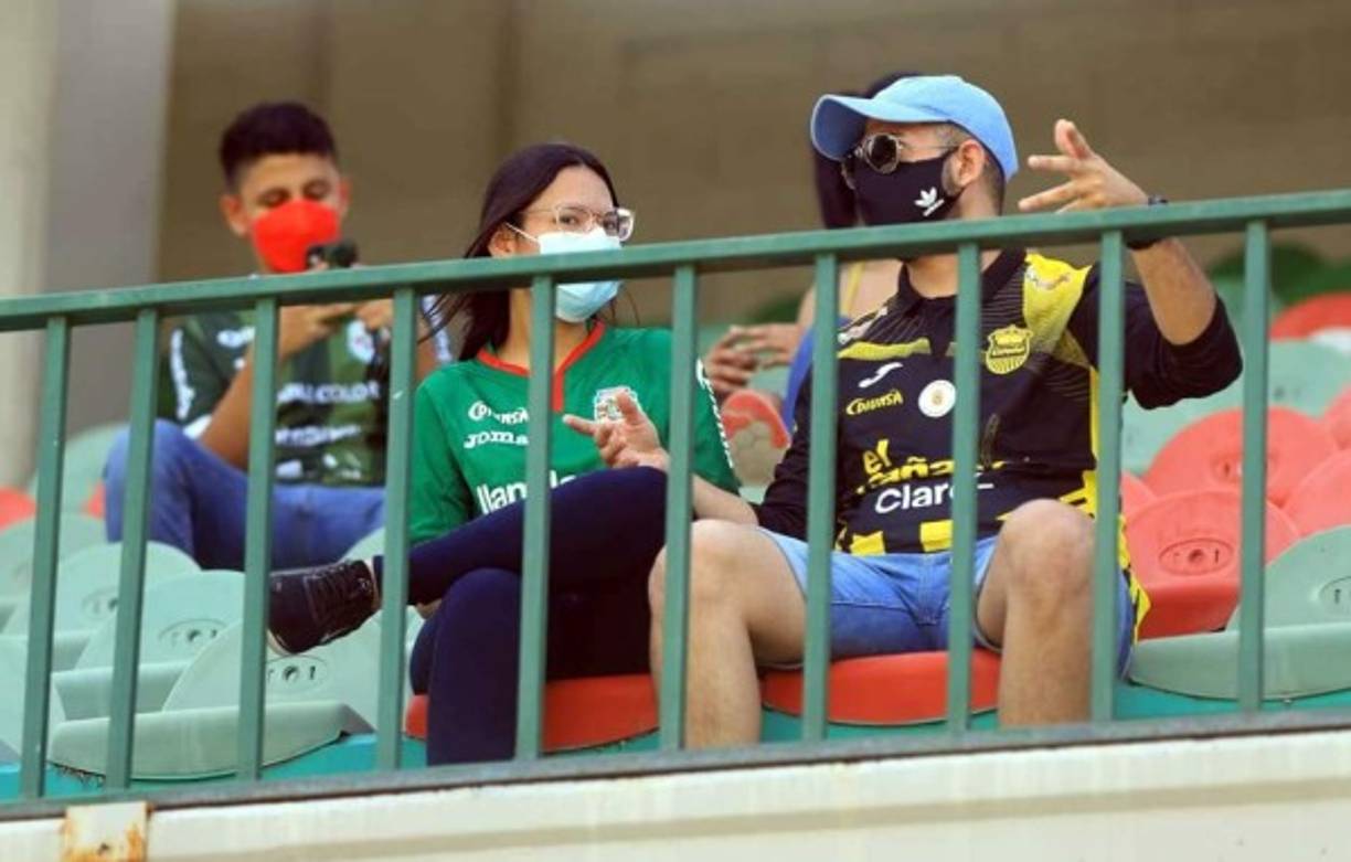 Una pareja de aficionados en el clásico, ella con la camiseta del Marathón y él con la del Real España.