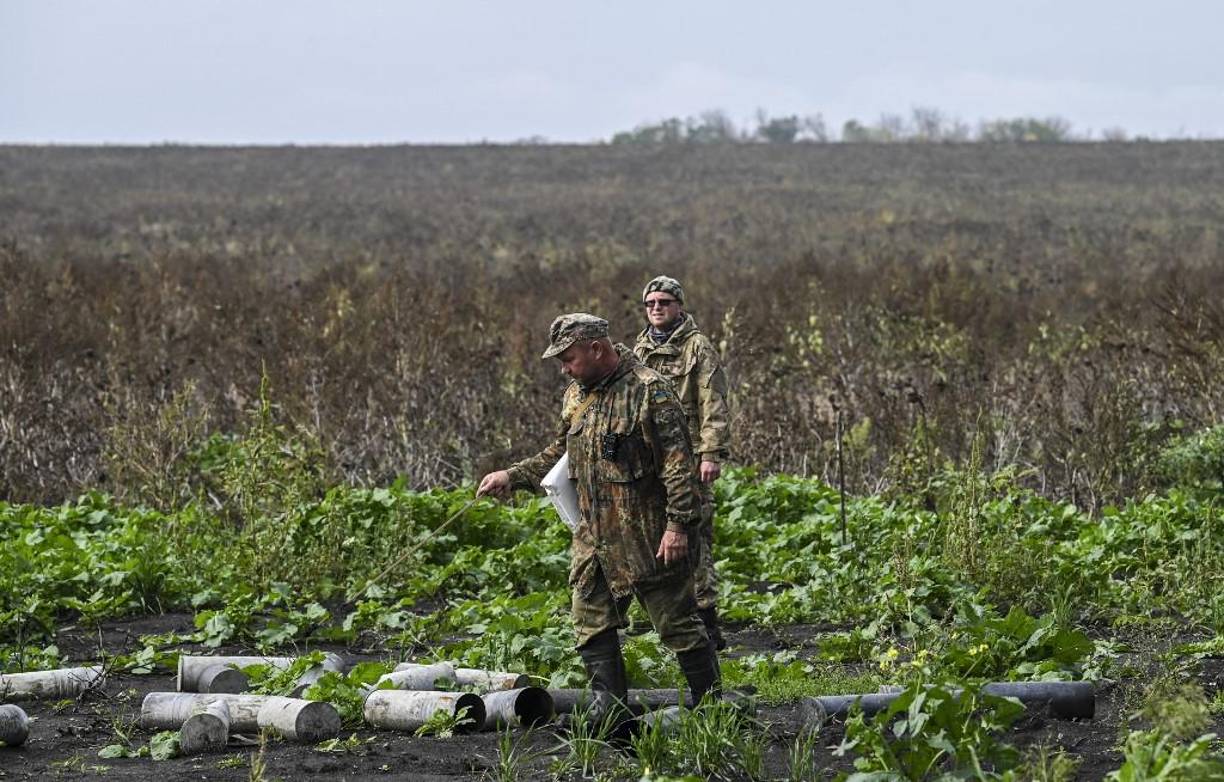 Miembros de una unidad ucraniana de remoción de minas revisan casquillos de artillería en una posición rusa abandonada cerca de Izyum, en el este de Ucrania.